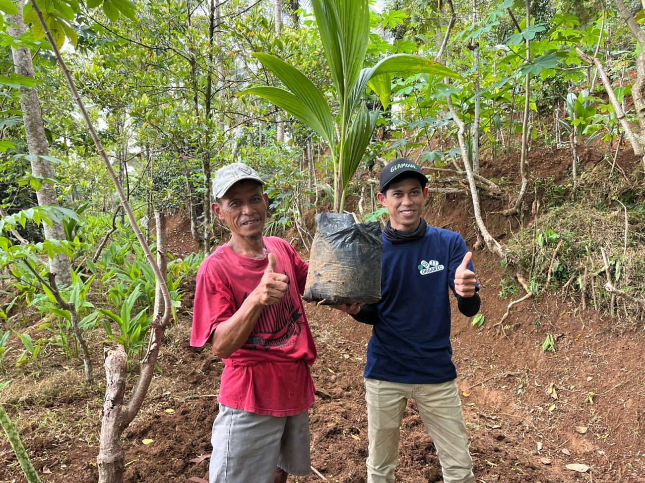 Farmer receiving a coconut seedling
